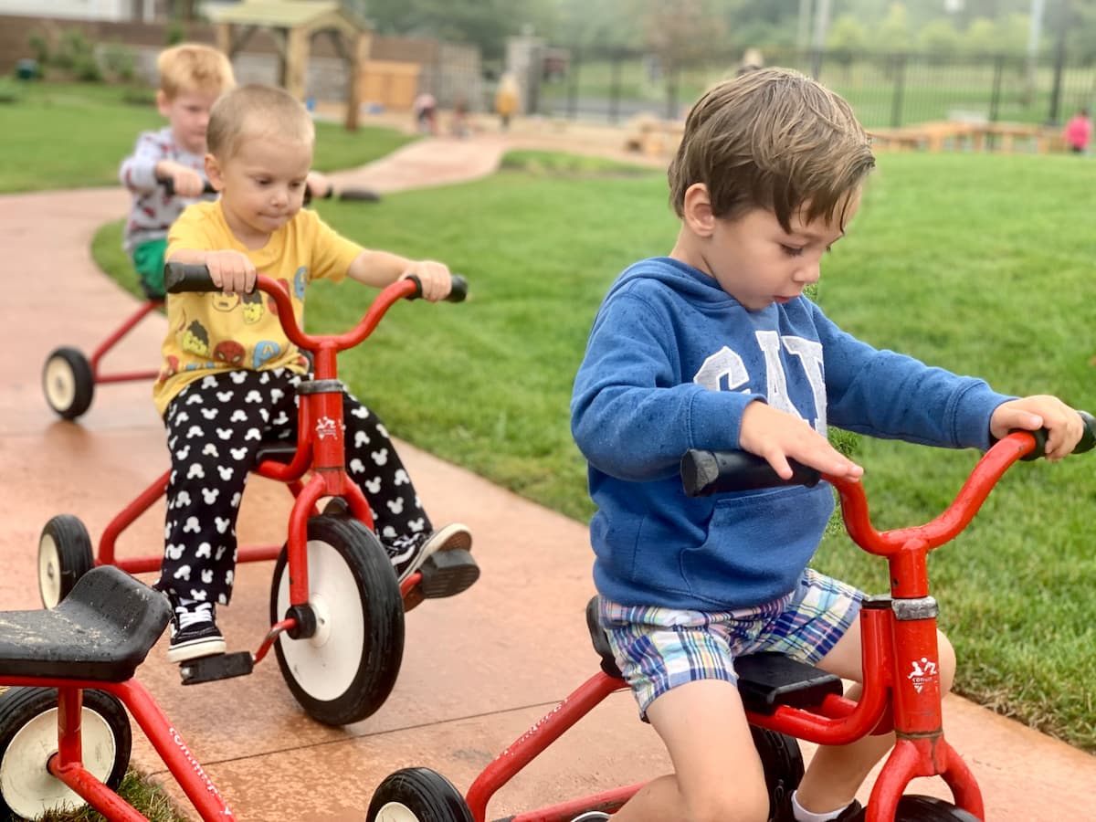 Pre-School students riding bikes on the outdoor playground